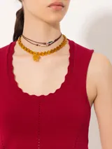 Top color borgoña de hilado frío, corte ajustado y largo hasta la primera cadera. Sin mangas, con cuello redondeado y profundo.