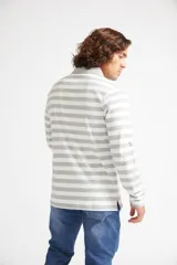 Polo de manga larga Mistral con diseño de rayas horizontales en tonos azules, cuello clásico y cierre frontal con botones.