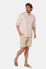 Bermuda clásica de lino color beige, de corte recto con bolsillos laterales y traseros ribeteados con botón.