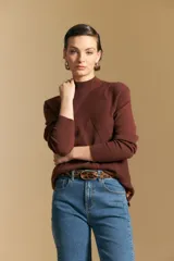 Polera de cuello alto en color blanco, confeccionada en tejido acanalado con un diseño geométrico de relieve que crea un efecto visual estilizado. Presenta un corte al cuerpo y mangas largas, ideal para usar como prenda base o principal.