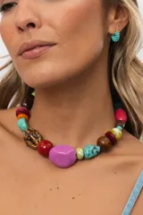 Collar corto compuesto por cuentas de cerámica, resina, piedras naturales y madera en tonos celestes, turquesas, verdes, marrones y beige, con cierre ajustable de cadena y mosquetón.