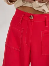 Pantalon de tiro medio-alto con pierna ancha, confeccionado en tela de rayón y poliéster. Presenta bolsillos plaque frontales, costuras a contratono y cierre frontal con botón.