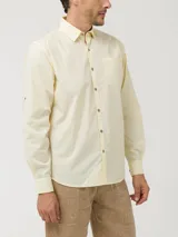 Camisa de manga larga RKF modelo Galiton, color amarillo, confeccionada en popelina 100% algodón orgánico. Cuenta con cuello camisero, botones de madera, un bolsillo frontal en el pecho con logo bordado y mangas ajustables.