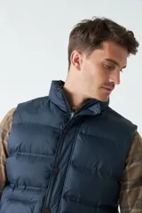 Chaleco azul marino de nylon con cierre frontal y bolsillos laterales.