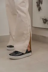 Pantalón de gabardina color beige, de corte recto y holgado, con pretina frontal, elástico en la parte posterior de la cintura y bolsillos laterales.