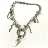 Collar plateado con cadena de eslabones y dijes colgantes: diente de tiburón, estrella de mar, concha marina, perlas y cuentas de cristal.