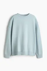 Buzo de corte oversized con cuello redondo, hombros caídos y puños y bajo acanalados. Presenta un diseño liso con interior cepillado suave.