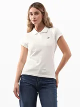 Chomba blanca de piqué de algodón regenerativo con corte slim, cuello tipo polo, cartera de dos botones, logo Tommy Hilfiger Script bordado en el pecho y bandera de Tommy Hilfiger bordada en la manga.