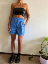 Short de cuero sintético celeste con cintura elástica y cordón ajustable.