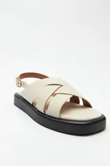 Sandalias color beige con capellada entrelazada y agarre ajustable en el talón. Plataforma de 3cm de alto y suela negra.