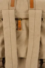 Mochila de lona estilo vintage con solapa frontal, bolsillos laterales y correas ajustables. Presenta detalles en cuero sintético y un parche decorativo en la parte superior.