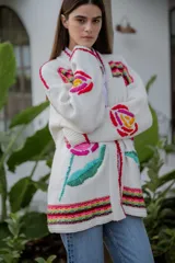 Cárdigan largo de punto color crudo con bordados florales multicolores hechos a mano.