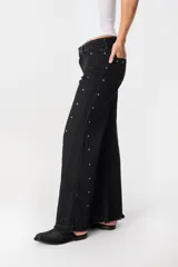 Pantalón de pierna ancha con acabado brillante, confeccionado en lino. Presenta un diseño de tiro medio con cierre de botón y cremallera, bolsillos traseros y etiqueta de marca en la cintura.