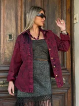 Camisa de denim color borgoña con efecto lavado, corte holgado, cuello clásico y cierre frontal con botones dorados.