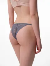 Tanga de algodón con diseño minimalista, presenta tiritas elásticas laterales y un pequeño lazo decorativo en el centro del frente.