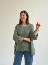 Sweater de punto calado en color verde seco, con escote redondo, mangas largas anchas y diseño holgado.