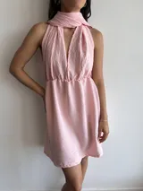 Vestido corto rosado con escote halter y falda acampanada.