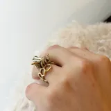 Anillo de bronce color dorado con forma de panal de abeja y una abeja en el centro.