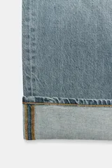 Pantalón de jean celeste de tiro medio, corte ancho y terminación con dobladillo.