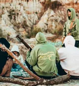 Hoodie verde con estampado en la espalda que dice "GlassyWaves Surf Company Ride Your Own Wave".