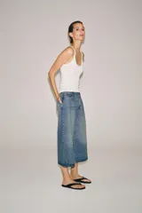 Bermuda de denim de tiro medio y corte wide leg, con diseño culotte, trabillas en la cintura y pliegues delanteros. Posee cinco bolsillos y cierre frontal con cremallera y botón.