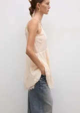 Vestido corto color crema con breteles finos y escote en V con encaje.