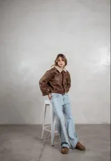 Campera de ecocuero color marrón, con forro interno de corderito sintético, cuello clásico, cierre frontal y bolsillos laterales.
