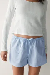 Pack de dos shorts de pijama con cintura elástica, cordón ajustable y aberturas laterales en el dobladillo. Uno presenta diseño a rayas celestes y blancas, y el otro diseño a rayas blancas y celestes.