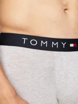 Pack de tres calzoncillos tipo trunk de algodón elástico color gris melange, con cintura elástica negra que presenta el logo y la marca Tommy Hilfiger en contraste.