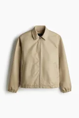 Campera de denim rígido color beige, con cuello, cierre frontal, bolsillos insertados al bies y un bolsillo interior. Puños y bajo con elástico revestido. Forrada.