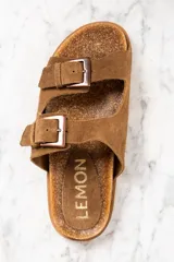 Sandalias marrones de cuero gamuzado con doble tira y hebillas metálicas.