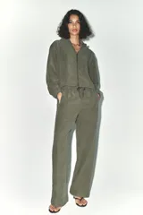 Cazadora bomber verde militar con capucha, cierre frontal con cremallera y bolsillos delanteros.