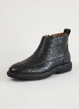Bota corta de cuero negro con textura granulada, diseño de puntera reforzada y suela de goma gruesa con relieve estriado. Cuenta con cierre lateral y tirador en la parte trasera.