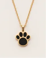 Dije de acero dorado con forma de huella de mascota, con relleno esmaltado en color negro.