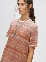 Vestido corto de tejido calado con cuello redondo y mangas cortas con puños a rayas en color contrastante. Diseño degradado en tonos lila y borgoña.