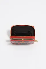 Billetera pequeña de estructura rígida con acabado brillante y estampado animal print en tonos rojos y negros. Presenta cierre de cremallera perimetral, logo metálico dorado en el frente y tarjetero interior.