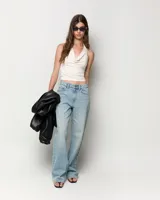 Jeans de tiro medio con corte recto desde la cadera hasta el bajo, de color celeste claro. Diseño clásico de cinco bolsillos con cierre de cremallera y botón metálico.