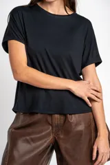 Remera negra de corte oversize, con mangas cortas y cuello redondo, confeccionada en tejido de viscosa y elastano de caída fluida.