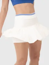 Falda plisada de corte A con pretina elástica y detalles de líneas en contraste. Incluye calza interna con bolsillo incorporado, diseñada para la práctica de deportes como tenis o pádel.