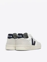 Zapatillas Veja V-10 blancas con detalles en gris y logo lateral en azul marino.