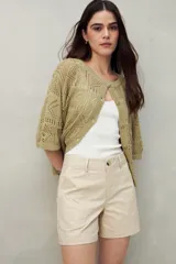 Short color verde militar, de tiro medio, con bolsillos delanteros y traseros.