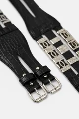Cinturón ancho de cuero de búfalo negro con textura efecto cocodrilo, diseño multipuntada con hebillas dobles delanteras y apliques metálicos plateados en el lateral.