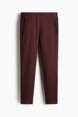 Pantalón jogger deportivo de corte ajustado, confeccionado en tejido funcional con tecnología DryMove para absorción de sudor. Presenta cintura elástica con cordón de ajuste y bolsillos laterales con cierre sellado.