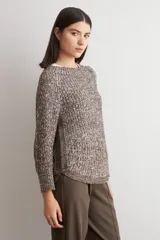 Sweater de punto con textura jaspeada en tonos marrones, de corte recto, cuello redondo y mangas largas. Presenta un diseño con ruedo curvo.