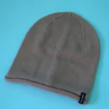 Gorro tipo beanie de punto de lana, con borde enrollado y etiqueta de marca cosida en el lateral.