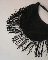 Cartera tipo hobo de gamuza color beige, con diseño amplio y detalle de flecos largos en todo el contorno. Cuenta con un asa superior con pespuntes artesanales y cierre principal.