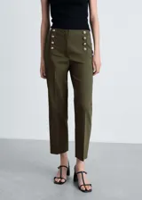 Pantalón de tiro medio y corte recto estilo crop, confeccionado en tejido mezcla de algodón. Presenta un diseño con doble hilera de botones decorativos efecto joya en la parte frontal, bolsillos laterales y cierre oculto con cremallera y gancho.