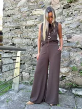 Blusa sin mangas color marrón chocolate, con escote volcado y silueta fluida. Confeccionada en viscosa con lycra, ofrece un tacto suave y caída ligera.