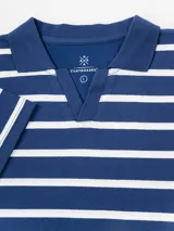 Remera de manga corta con diseño a rayas horizontales en color blanco y beige, cuello polo con escote en V y calce relajado.