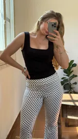 Pantalón de lycra blanco con estampado de lunares negros, corte ajustado y tiro alto.